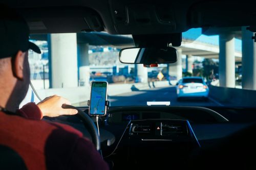 Person holding a phone inside a car after an Uber rideshare accident in Texas